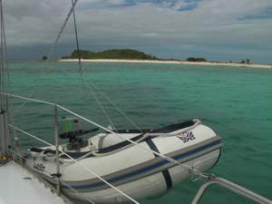 Dinghy opgehesen aan een val op de achtergrond Sandy Island